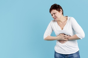 Kobieta trzymająca się za klatkę piersiową z powodu ostrego bólu – neuralgia międzyżebrowa.